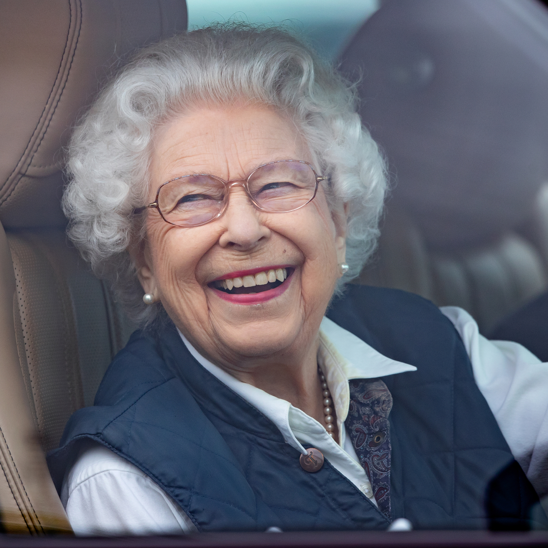 Queen Elizabeth laughing driving a car