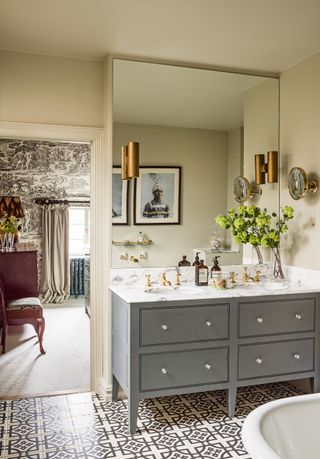 Traditional bathroom with grey vanity unit and victorian style floor tiles, photograph Mel Yates