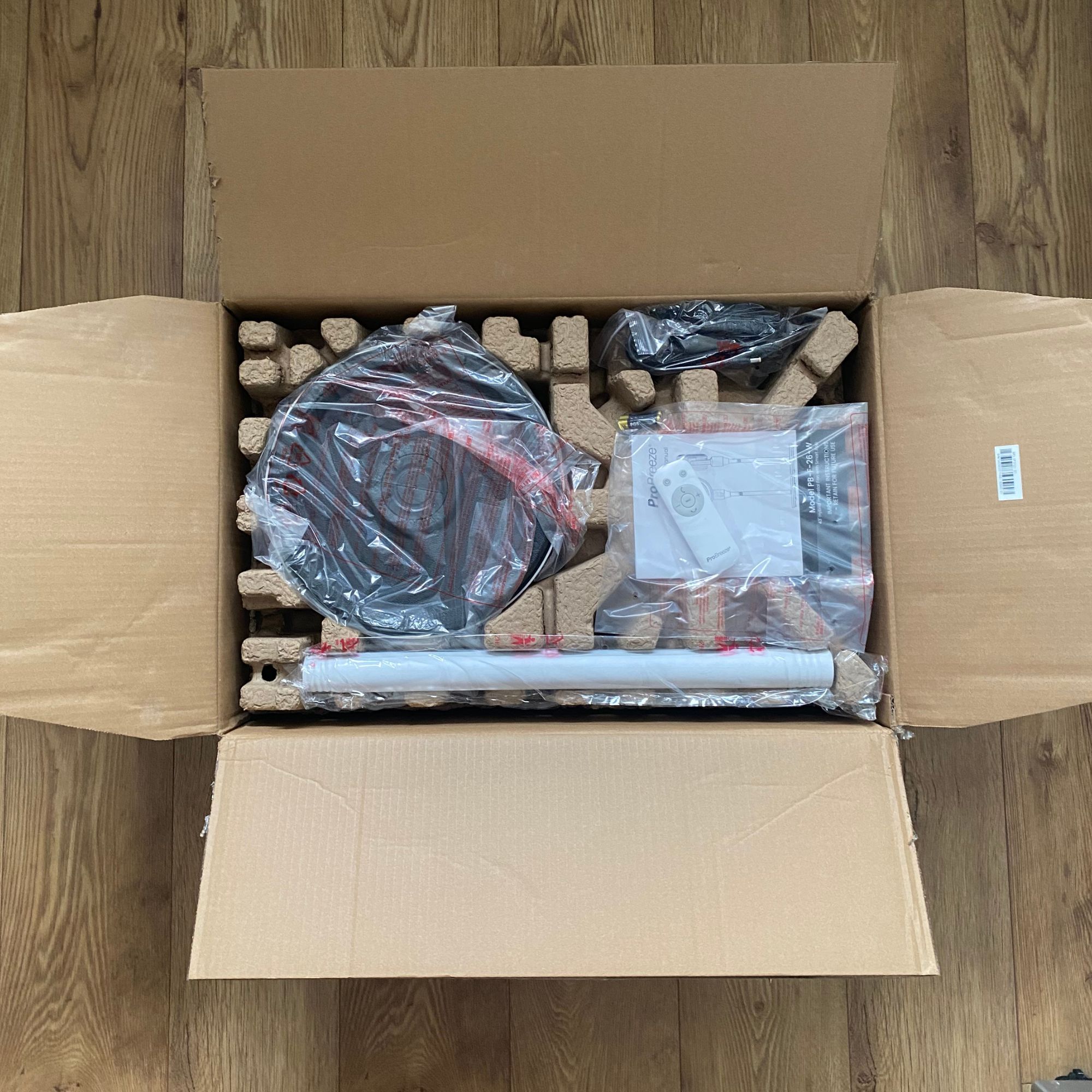 Open packaging of the Pro Breeze Airflo 43'' Hybrid Pedestal Fan on a wooden floor