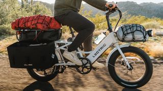 Man riding Lectric XPedition e-bike with camping gear