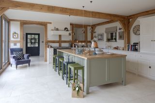 large green kitchen island in oak frame house