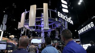 Attendees at a conference looking up at a range of wireless antenna on display by Ericsson