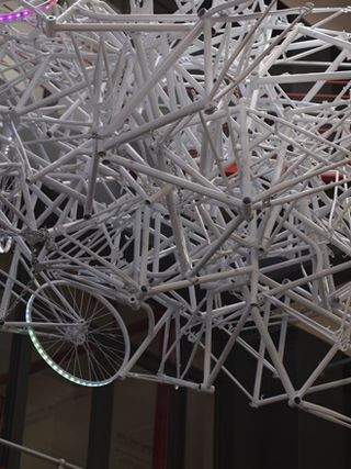 A giant chandelier sculpture composed of scrap bicycle frames hanging from ceiling