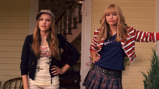 Emily Osment and Miley Cyrus as Lilly and Hannah standing on a porch in Hannah Montana: The Movie