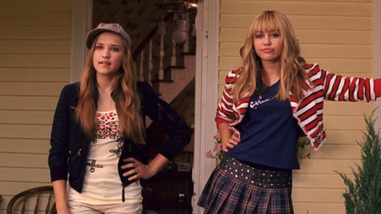 Emily Osment and Miley Cyrus as Lilly and Hannah standing on a porch in Hannah Montana: The Movie
