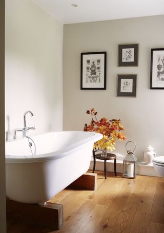 freestanding bathroom with decorative autumn leaves and pictures