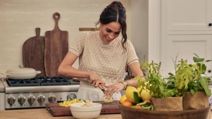 A still from Meghan Markle's new Netflix series, showing the Duchess of Sussex slicing a lemon