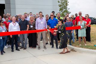 The ADI Global team using large scissor to cut the red ribbon to their new center in Dallas.