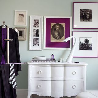 blue room with white cupboard and walled pictures