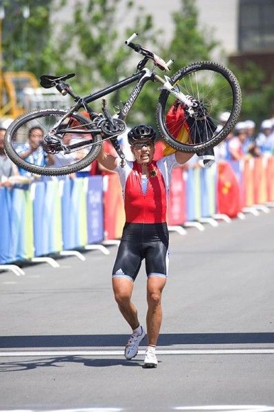 Sabine Spitz crossed the line in first carrying her bike