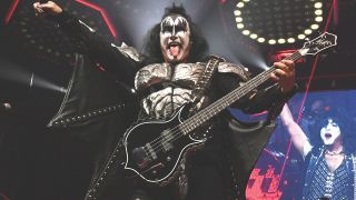 Gene Simmons on stage with Kiss in makeup with his tongue sticking out