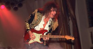 Yngwie Malmsteen in 1985, playing a Candy Apple Red Fender Stratocaster, dressed in some extravagant stagewear – even for the period.