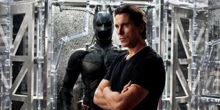 Christian Bale as Bruce Wayne in front of his batsuit in The Dark Knight