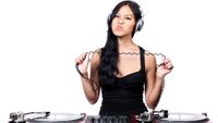 A young female DJ stretching out the cord from her headphones and making a mean face.