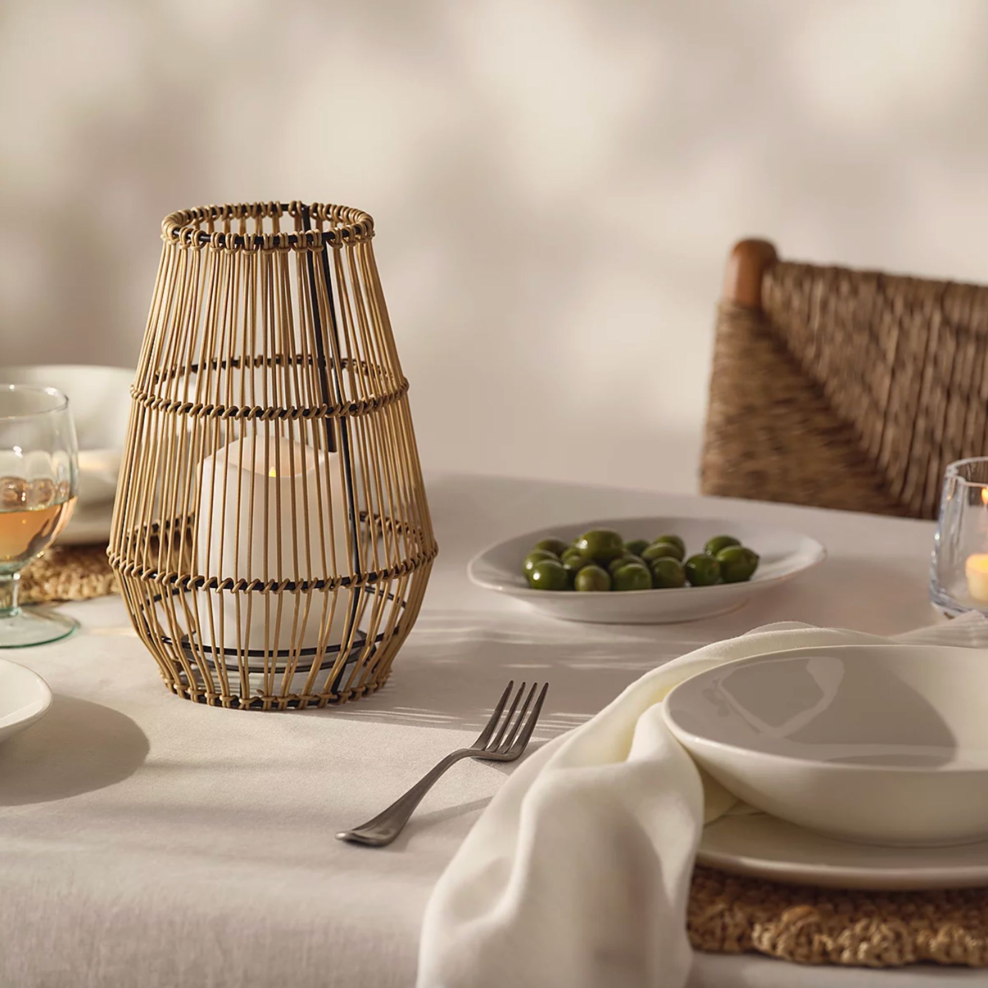 The White Company, Solar Wicker Lantern with LED Candle on white tablescape with bowl of olives