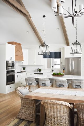 white kitchen with open plan aspect, dining table, vaulted ceiling
