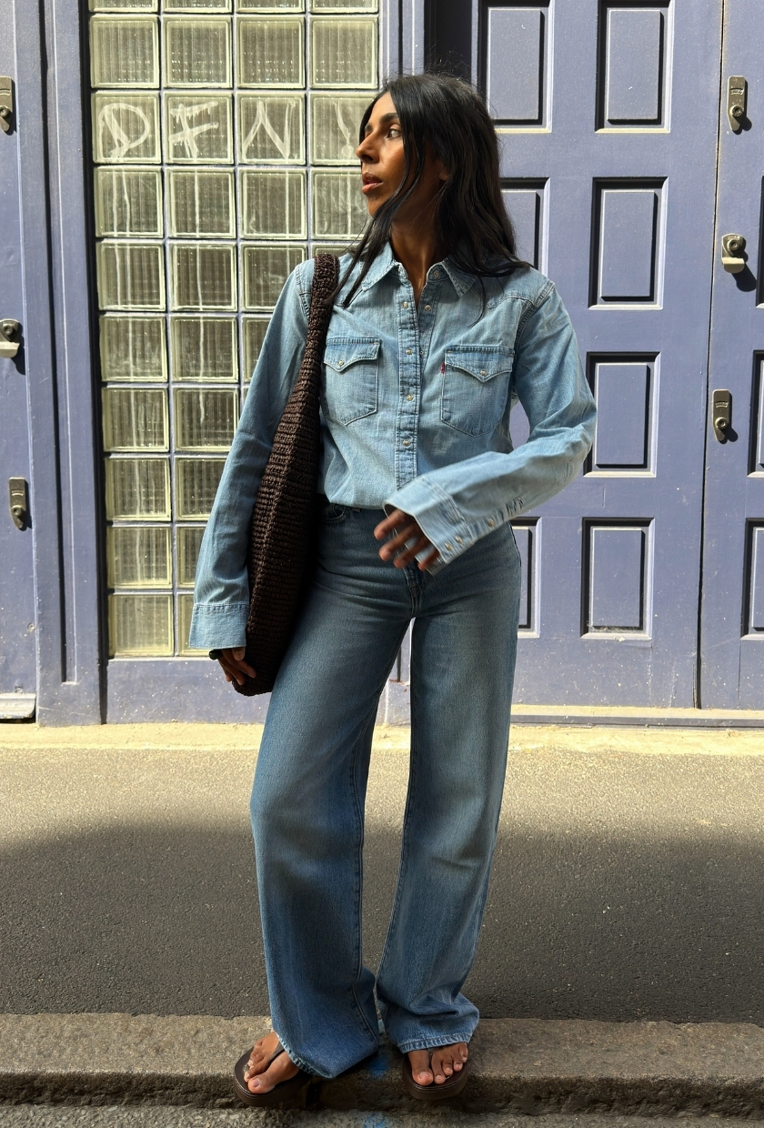 monikh dale wears a denim shirt tucked into high waisted jeans