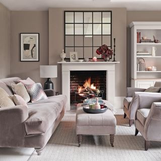 living room with grey wall grey sofa with cushions fireplace and white shelve