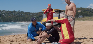 A surfer gets medical attention from Nikau and John in Home and Away