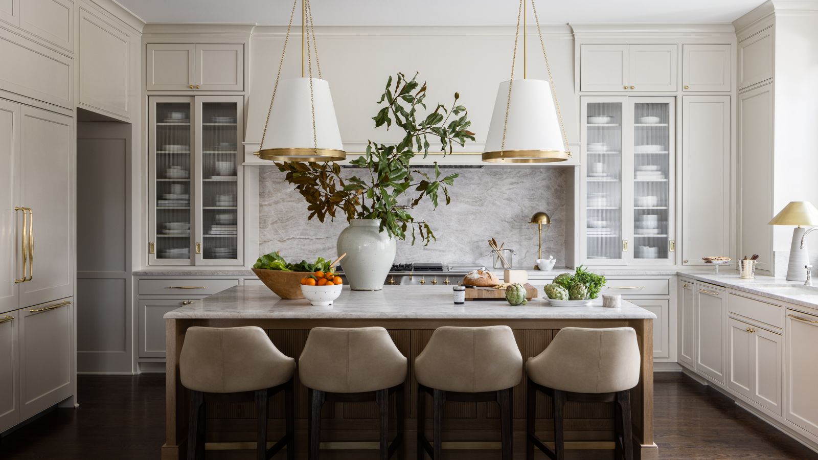 kitchen with neutral cabinets, kitchen island with bar stools and large pendant lights
