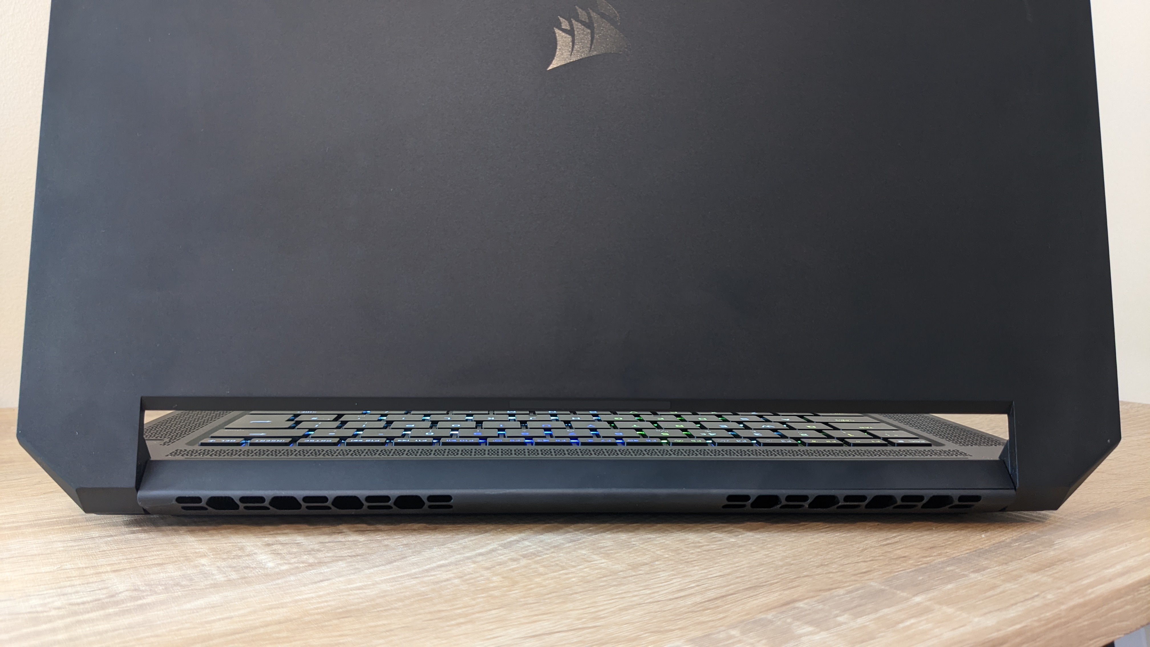 Corsair Voyager a1600 laptop on a wooden desk, shown from behind to display the cooling vents.