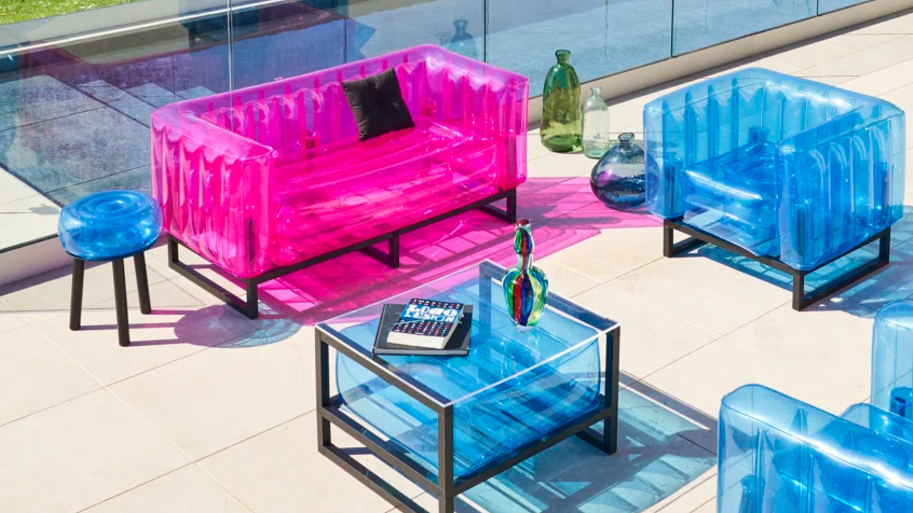 Mojow Yomi 151cm Wide Outdoor Patio Sofa with Cushions in pink with coordinating blue armchairs and coffee table by a pool