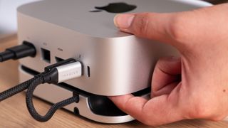 Pressing the Mac mini M4's power button with the Satechi Mac Mini Hub underneath it