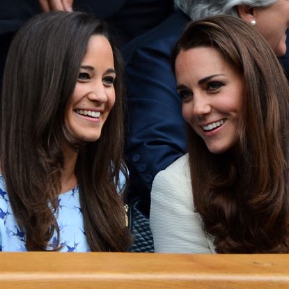 Pippa and Kate Middleton smile and both have long brown hair as they attend Wimbledon in 2012