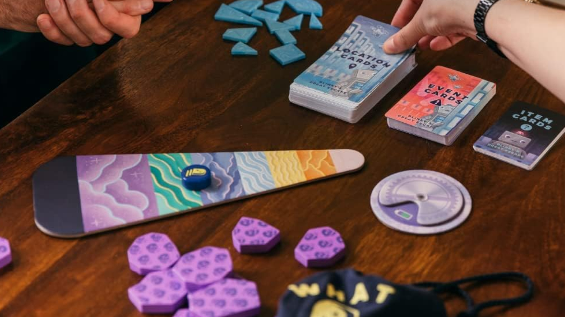 A series of tokens, pieces, and cards on a wooden table