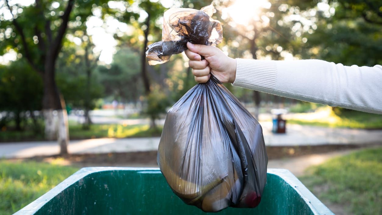 A person throws away garbage.