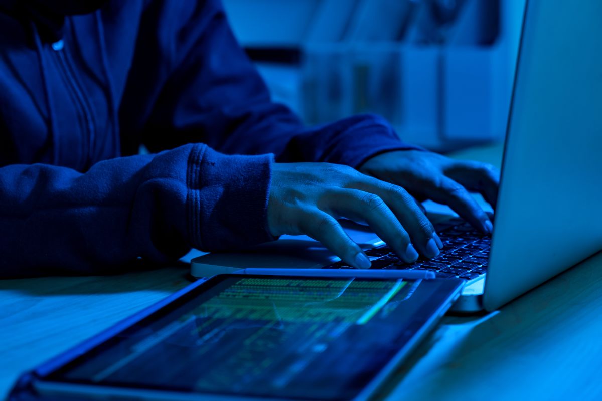 Anonymous Sudan: Stock photo of a hacker typing on keyboard in darkness