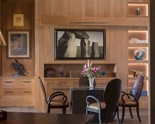 A home office with wood panelled walls and a fossil collection displayed on shelves