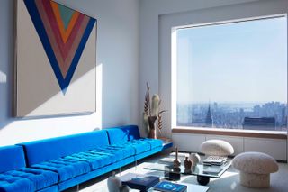 432 Park Avenue penthouse interior with blue sofa and skyline view