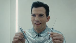 Ashton Kutcher's The Corporation holding two syringes in The Beauty Season 1