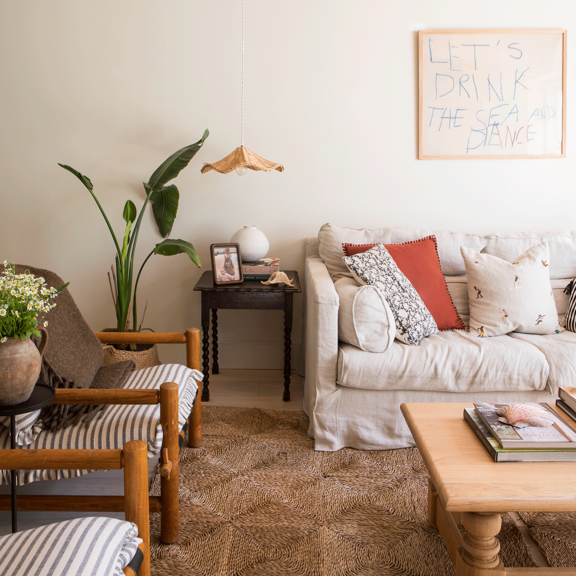 a neutral living area with cream sofas and wooden armchairs, and a jute rug