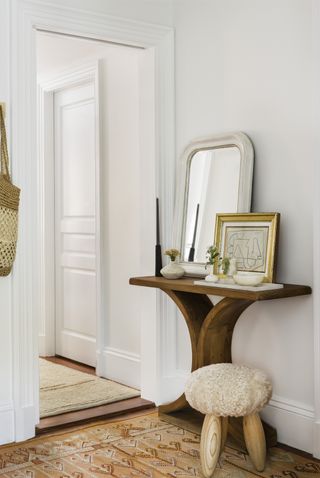 hallway with wood side table, mirror, art and objects