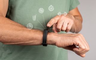 A man using his smart watch to record his habits.