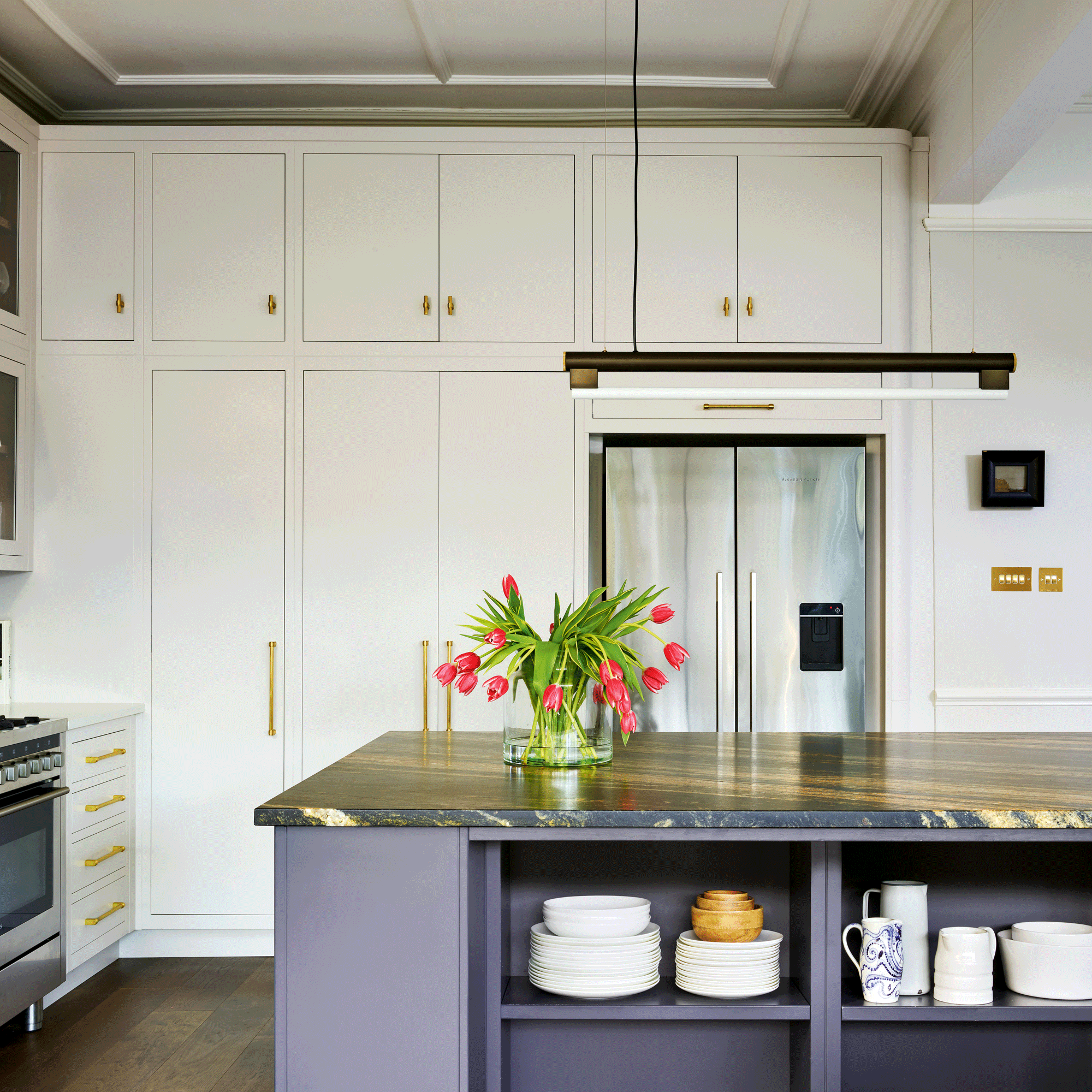 White kitchen with grey island and dark marble worktop