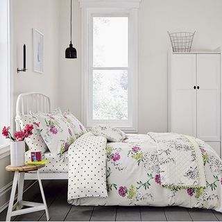 bedroom with floral printed white bedding set on bed