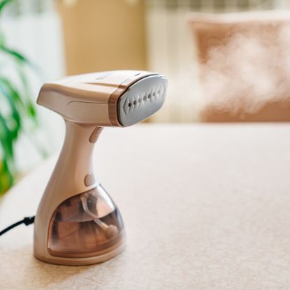 Portable handheld clothes steamer on tabletop