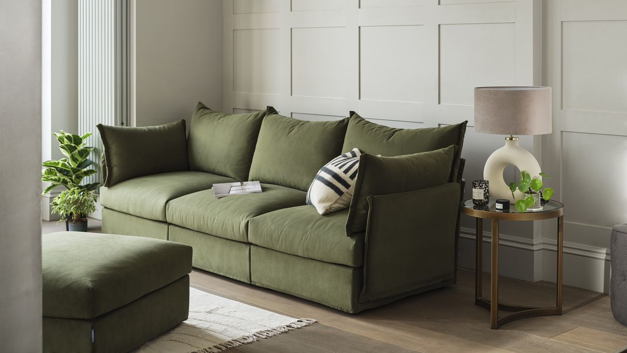 Swyft green velvet sofa in living room with cream wall panelling.