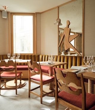Interior of Café Compagnon, with tables, wine glasses and mustard and red seating