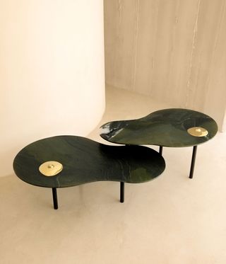 Black curved tables with gold breasts on them