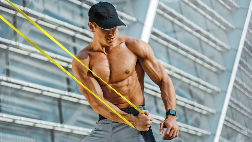 Man outdoors using resistance band for upper body workout