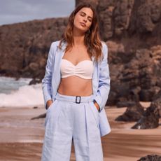 Female modelling a blue Mint Velvet pant suit on the beach