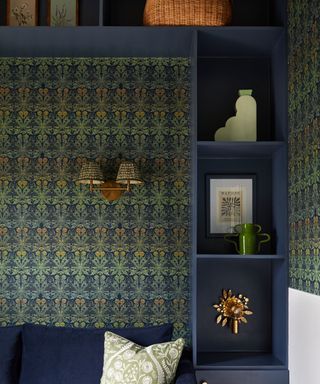 living toom with dark green patterned wallpaper, dark blue sofa and dark blue shelving