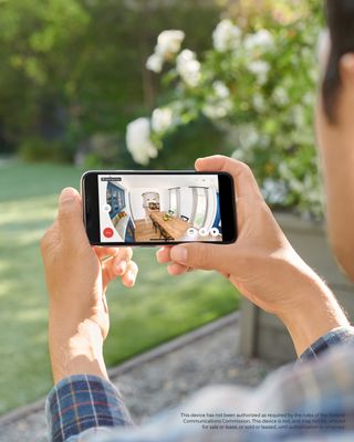A person viewing a live feed of their home on their phone