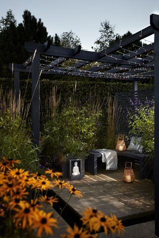 covered patio with lighting, bench seating and lanterns