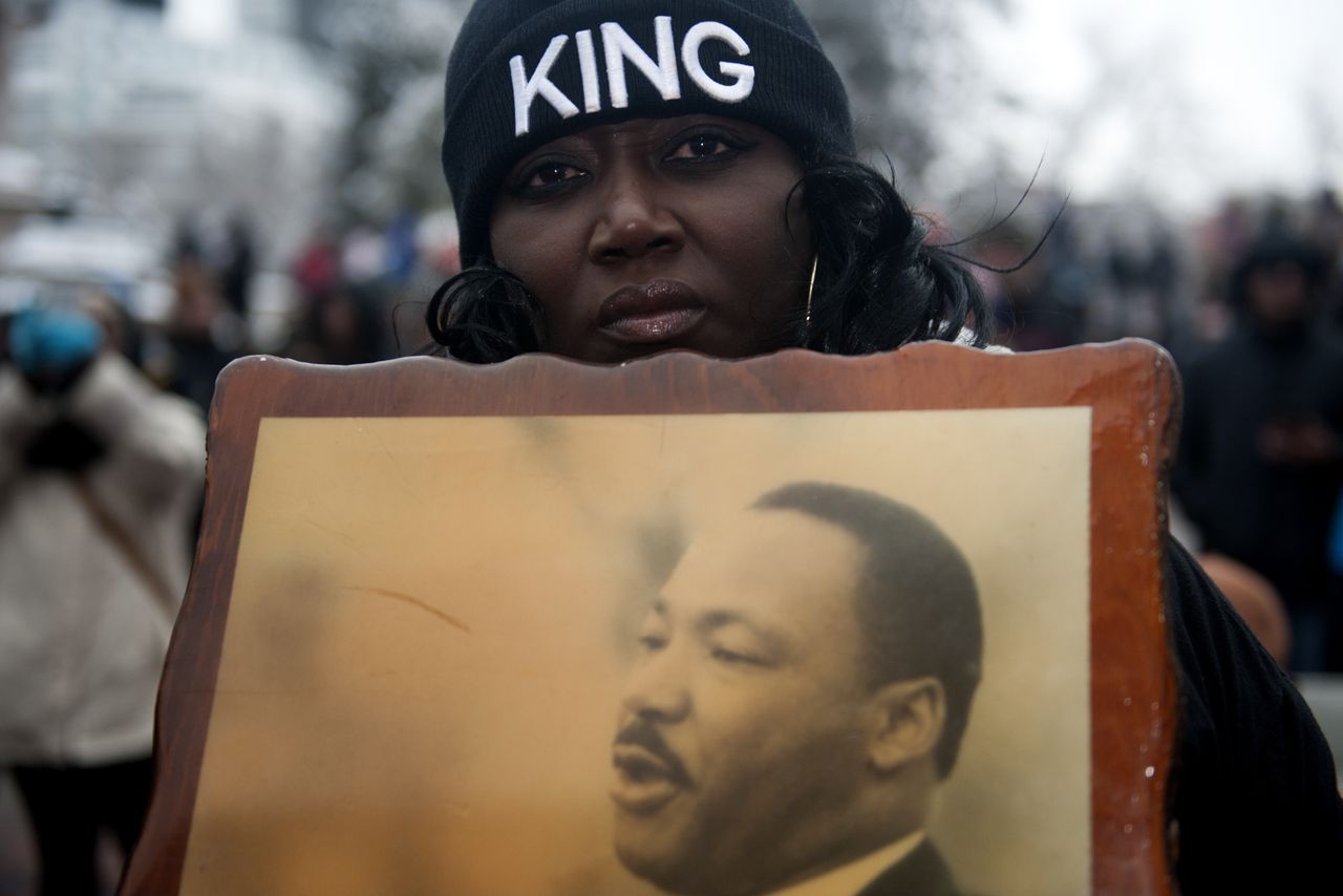 A woman holds a picture of Martin Luther King