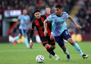 William Saliba of Arsenal runs with the ball whilst under pressure from Evanilson of AFC Bournemouth (obscured) during the Premier League match between AFC Bournemouth and Arsenal FC at Vitality Stadium on October 19, 2024 in Bournemouth, England.